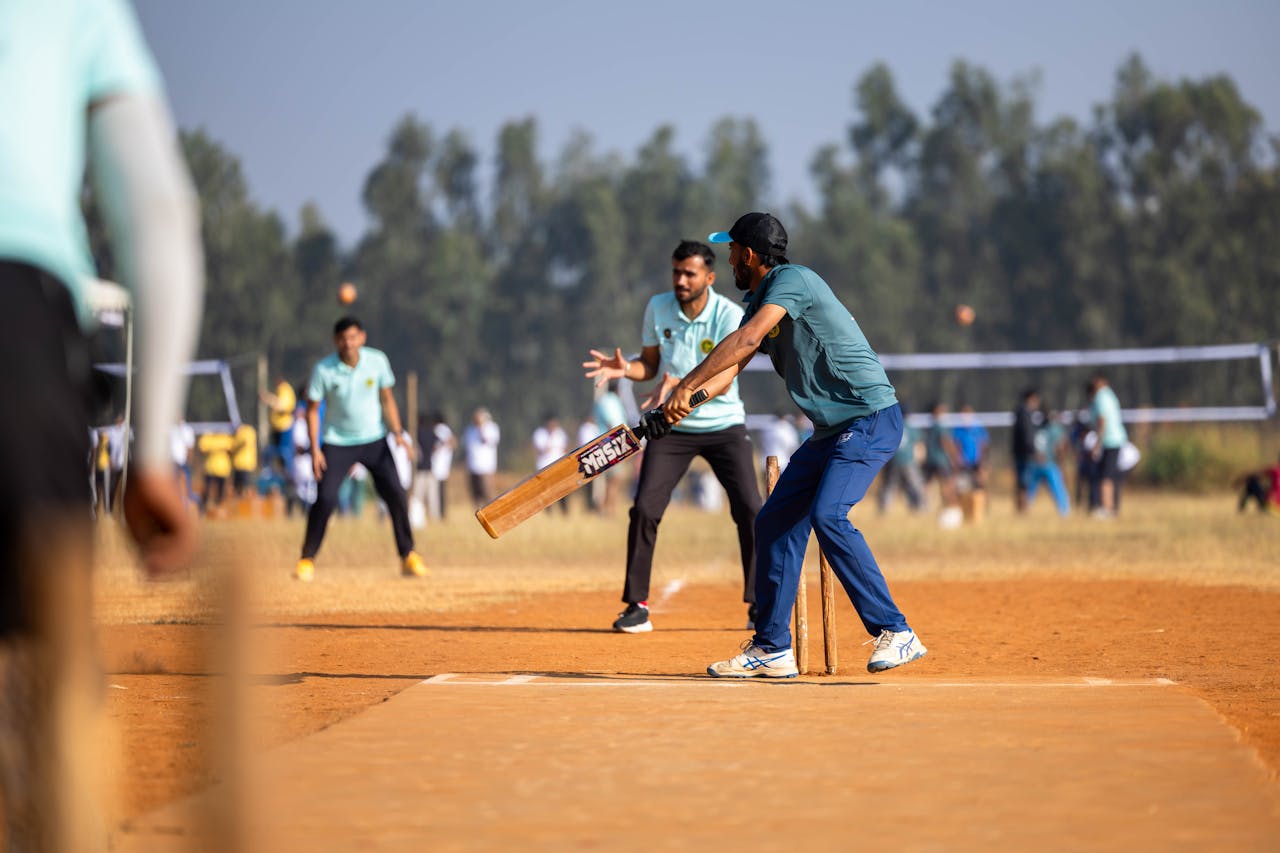 Dynamic scene of a cricket match capturing the batsman in action on an outdoor field.